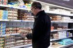 FILE - A shopper checks eggs before he purchases at a grocery store in Glenview, Ill., Tuesday, Jan. 10, 2023.