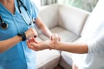 A nurse checks a patient's blood pressure.