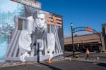 A woman walks her dog near a mural depicting Buster Keaton from his 1926 film, The General, in Cottage Grove, Ore. Fans gathered in the town to celebrate the film's centennial with a conference, a look alike contest, 1920s costume party and tours of film locations.