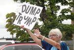 A protester in Beaverton, Ore., waves to passing cars at a small demonstration on June 22, 2025, against the bombing of nuclear sites in Iran.