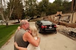 Allen Sather and his wife Kimberley embrace at the duplex they rent on W. Indian Trail Rd. after it burned in a wildfire in Spokane, Wash., Sunday, Aug. 2, 2026.