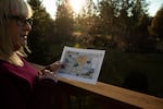 Terri Holm holds a map of the Caldera Ranch development as she stands on a deck in her backyard in Bend, Ore., on Dec. 5, 2024. Caldera Ranch will be built just on the other side of her backyard fence.