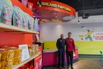 A father and son stand in a brightly colored store with shelves of popcorn.