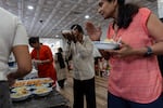 Worshippers are offered food at Sir Hanuman Mandir, a Hindu temple in Alpharetta, Ga., Tuesday, July 23, 2024.