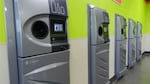 A row of sparkling clean reverse vending machines greet customers at the grand opening of the Medford BottleDrop center.
