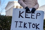 A content creator on TikTok holds a protest sign outside the U.S. Supreme Court Building on Jan. 10, 2025, in Washington, D.C.