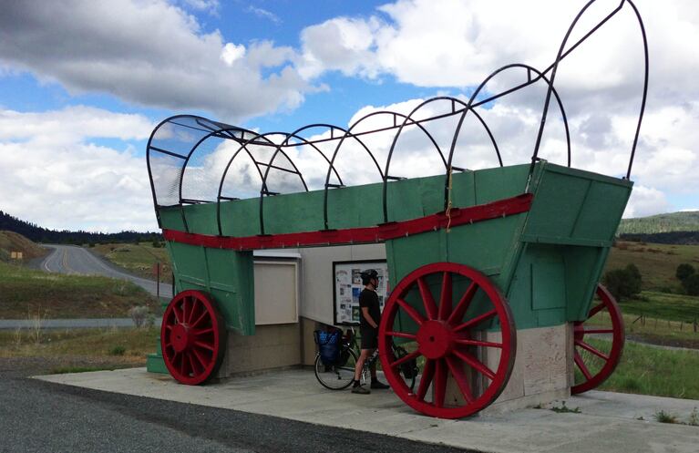 A cyclist stops at an interpretive site along the Old West Scenic Bikeway.