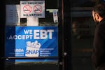 A customer walks into a bakery with a SNAP EBT information sign displayed on the front door in Chicago, Sunday, Nov. 2, 2025.