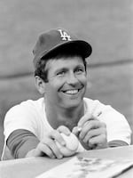 Lefthander Tommy John of the Los Angeles Dodgers signs an autograph before a game on Aug. 12, 1977.
