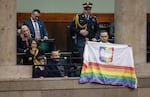 Polish filmmaker and LGBTQ+ activist Bart Staszewski holds a rainbow Pride-themed flag on the gallery of the Polish Parliament as designated Polish Prime Minister Donald Tusk gives a speech to present his program to lawmakers in Warsaw on Dec. 12.