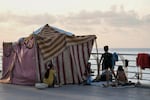 A displaced family fleeing the Israeli airstrikes in the south, sits next to their tent on Beirut's corniche, Lebanon, Monday, Oct. 14, 2024.