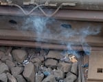 Smoking embers from the building land on nearby train racks at a fire in Northwest Portland, Ore., on Aug. 2, 2026.