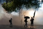 FILE - Protesters navigate a cloud of tear gas outside of the U.S. Immigrations and Customs Enforcement building in Portland, Ore., Oct. 18, 2025. Officers used a barrage of chemical agents and munitions on the nonviolent protesters after the driveway was cleared.