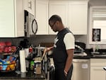 Samuel Kangethe cooks in his home on July 3, 2025, in Lansing, Michigan.