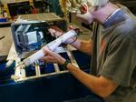 Sean Crimmins, a senior in engineering at the University of Nebraska, loads the robotic arm into its case on Aug. 11 before a shake test.