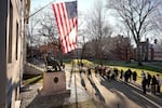 FILE - People take photos near a John Harvard statue, left, on the Harvard University campus, Jan. 2, 2024, in Cambridge, Mass.