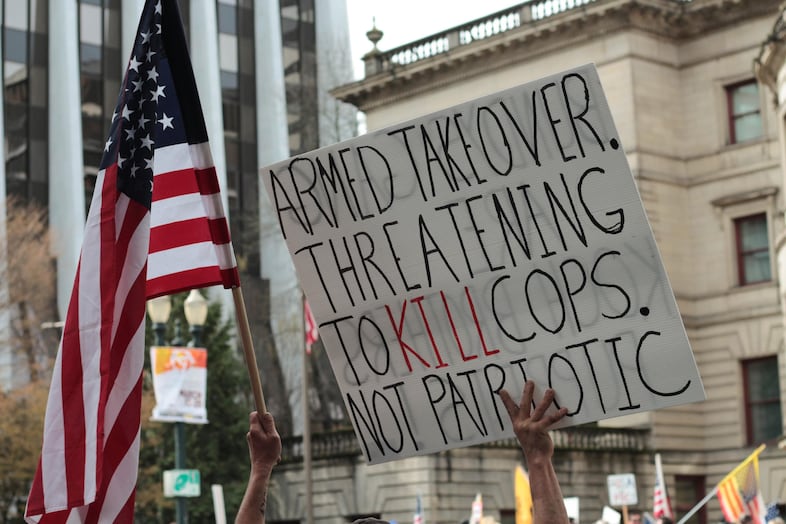 A counterprotester holds a sign across the street from a rally in support of LaVoy Finicum outside the federal courthouse in Portland on March 5, 2016.