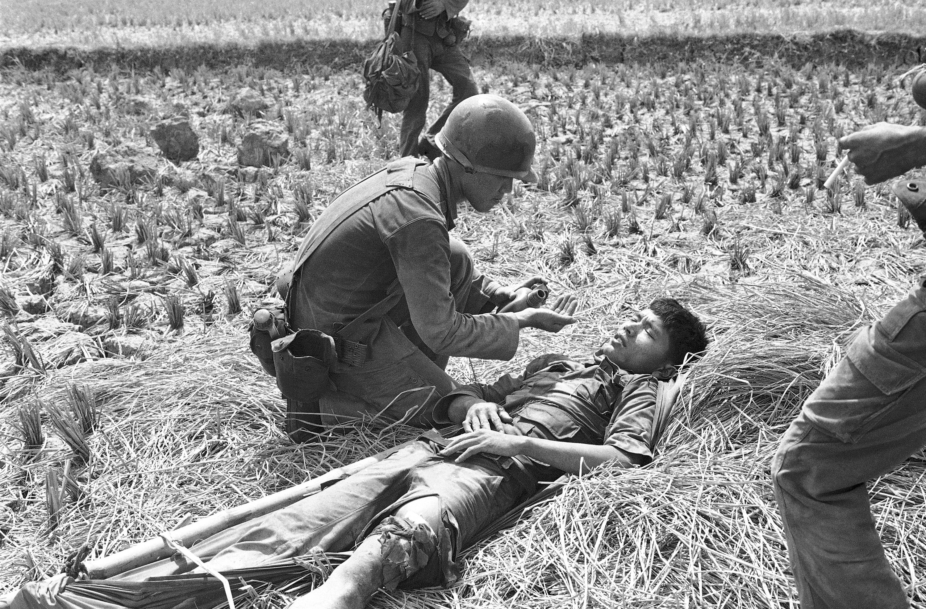 A South Vietnamese medic comforts a trooper wounded in the leg during a battle in Long An province, southwest of Saigon, on April 18, 1975.