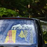 The hearse carrying the coffin of Queen Elizabeth II covered with the Royal Standard of Scotland and a flowers is driven away from Balmoral Castle in Ballater.