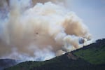 A helicopter flies near the Cottonwood Fire in Beaver, Utah, Tuesday, June 30, 2026.