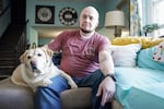 Kevin Conlon sits with his service dog Nova at home in Upstate New York. 