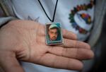 A woman shows a pendant with a portrait of Gustavo Trujillo, who disappeared in 2010 in Poza Rica, Veracruz, Mexico.