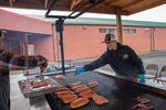 Longhouse cooks Freddy WarBonnet, right, and Andrew Wildbill grill up salmon, an important first food, for the Confederated Tribes of the Umatilla Indian Reservation winter solstice feast on Dec. 21 in Mission, Ore.