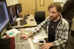 Greg Martin, a student in the Biochemistry and Molecular Biology Graduate Program, works on an older version of the new cryo-electron microscopes. 