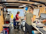 Scientists Jill Janak (right) and Kate Deters collect information and tag juvenile lamprey inside a trailer at Lower Granite Dam.