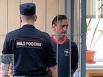 In this photo taken from video released by Khamovnichesky District Court press service on July 18, U.S. citizen Michael Travis Leake stands in a cage in a Moscow courtroom before being convicted of drug trafficking charges and sentenced to 13 years in prison.