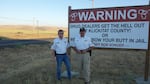 Klickitat County Sheriff’s Posse members Shane Cagle, left, and Brian Paul stand in front of a sign that greets people at the county line.