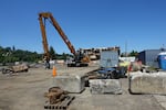 Construction cranes scooped busily at the former Blue Heron Paper Mill during demolition on June 5, 2024.