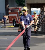 A Gresham firefighters gathers hose during a training at the Gresham Fire Department training division Sept. 4.