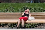 A woman sunbathes in a park in Milan, Italy, Tuesday, July 16, 2024. Weather alerts, forest fires, melting pavement in cities: A sizzling heat wave has sent temperatures in parts of central and southern Europe soaring toward 40 degrees Celsius (104 Fahrenheit) in some places.