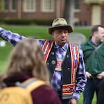 Roger Amerman points into the distance while teaching outside of the Long Tent on Whitman College’s Ankeny Field in April 2022.
