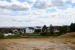 A newly rebuilt home stands next to an empty lot in the Louisville neighborhood. Wildfires are among the climate-related impacts Boulder County cites in its lawsuit against ExxonMobil and Suncor Energy.