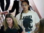 WNBA star and two-time Olympic gold medalist Brittney Griner is escorted to a courtroom for a hearing in Khimki just outside Moscow, as her trial begins on Friday.