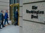 People enter The Washington Post's headquarters. The newspaper is cutting nearly 10% of its jobs through voluntary buyouts.