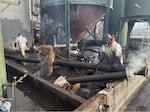 In this photo provided by the U.S. EPA, crews at the J.H. Baxter facility in Eugene, Ore., remove non-asbestos wrapped piping between container tanks ahead of asbestos abatement activities in December 2024.