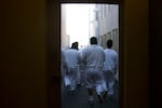 FILE - Detainees walk toward the outdoor recreation area on Tuesday, Sept. 10, 2019, at the Northwest ICE Processing Center in Tacoma.