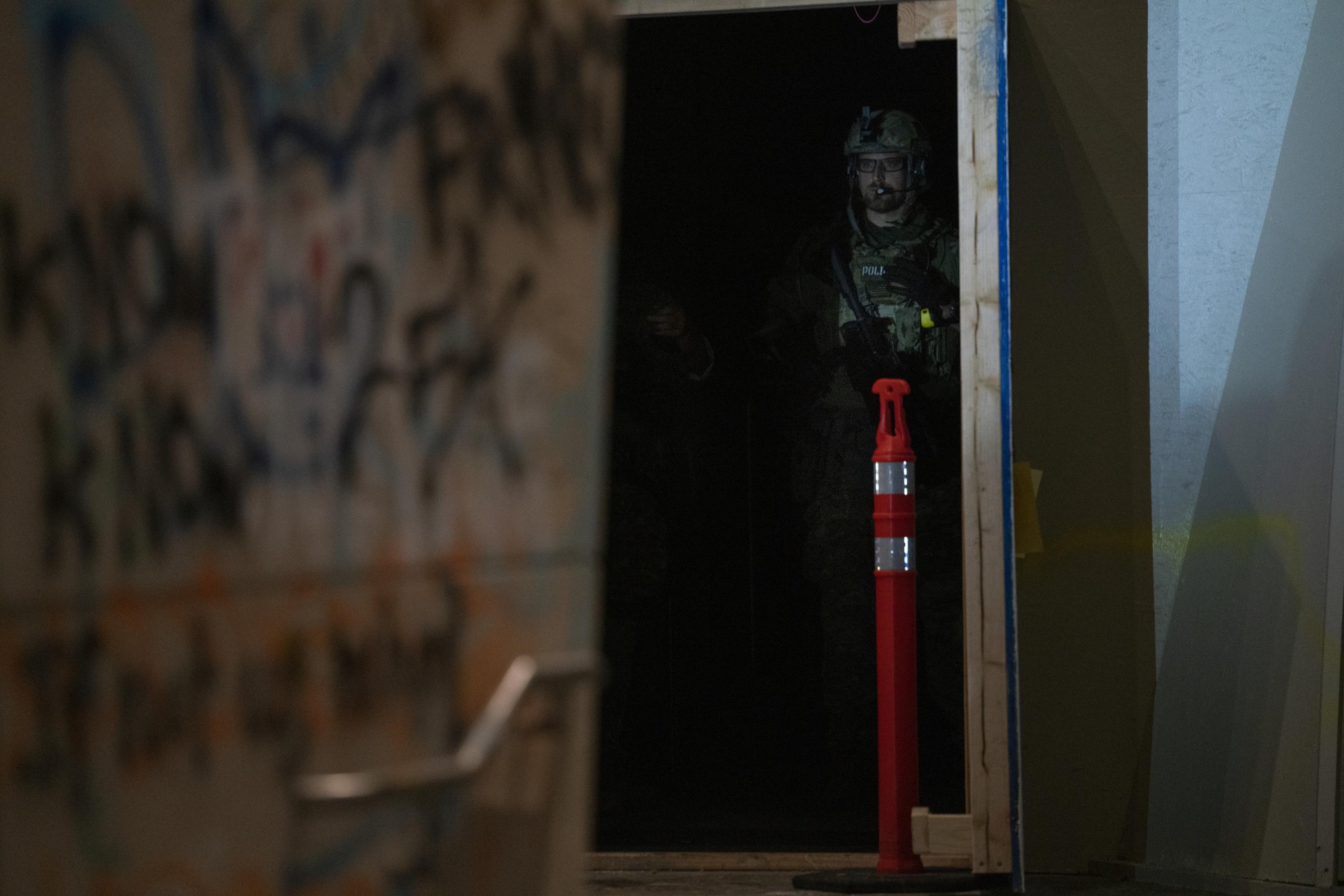 A federal officer peeks from behind a door to the Mark O. Hatfield federal courthouse in Portland, Ore., on July 12, 2020. Federal law enforcement officers have increased their presence and escalated tactics against people protesting police brutality and systemic racism.