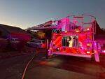 Firefighters from Tualatin Valley Fire & Rescue prepare to extinguish any fire that erupts from a small plane that had crashed Tuesday, Oct. 3, 2023, into a home in Newberg, Oregon.