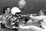 Bobby Allison, center, holds race driver Cale Yarborough's foot after Yarborough, right, kicked him following the Daytona 500 auto race in Daytona Beach, Fla., Feb. 18, 1979.