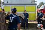 San Miguel Fire and Rescue firefighters, who traveled from the central California city to help fight the Akawa Butte Fire, talk during down time at camp.