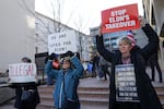 Demonstrators raise signs at a rally to protest the closing of the Consumer Financial Protection Bureau (CFPB) and the work-from-home order issued by CFPB Director Russell Vought outside its headquarters last month in Washington, D.C.