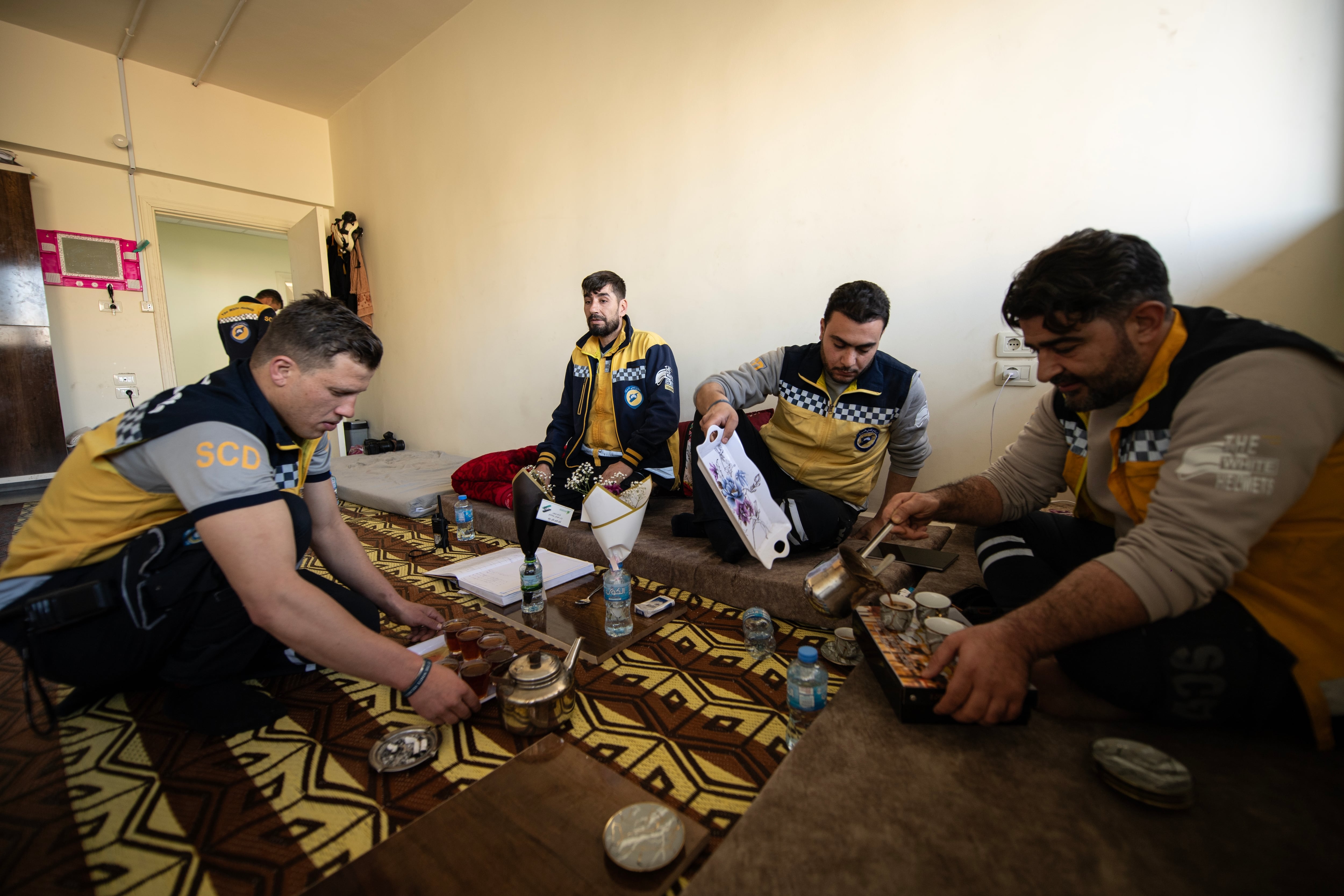White Helmet members (from left to right) Qassem Masarawi, Ibrahim al-Rihani, Tarek Taleb and Mustafa Bakkar pour coffee for an Eid celebration inside the Kafr Sousa firehouse.