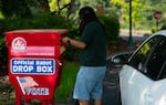 FILE - A person drops off a ballot in a ballot box at Washington State University’s Vancouver campus in Vancouver, Wash. on Aug. 4, 2026.