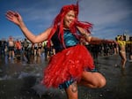 A mermaid takes the annual polar bear plunge at Brooklyn's Coney Island beach last year. More people are cold plunging on a regular basis for health benefits, but hype outpaces research for now.