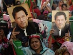 Supporters carry placards displaying a portrait of Imran Khan during a protest in Karachi on March 19, 2023, demanding release of arrested party workers in recent police clashes.