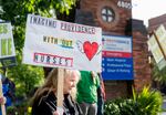 Crystal Dean, a behavioral health registered nurse, left, participates in a picket line outside the Providence Portland Medical Center.